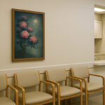 医院の待合室の白い壁に、満月の下で咲く花を描いた写意画が飾られている様子。