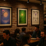 レンガ壁のレストランに三枚の写意画が飾られ、食事を楽しむ人々が座っている風景